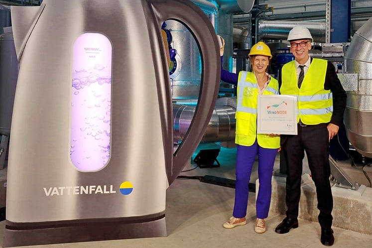 Inbetriebnahme Power-to-heat Anlage in Berlin  - zwei Personen vor einem riesigem symbolisierten Wasserkocher
