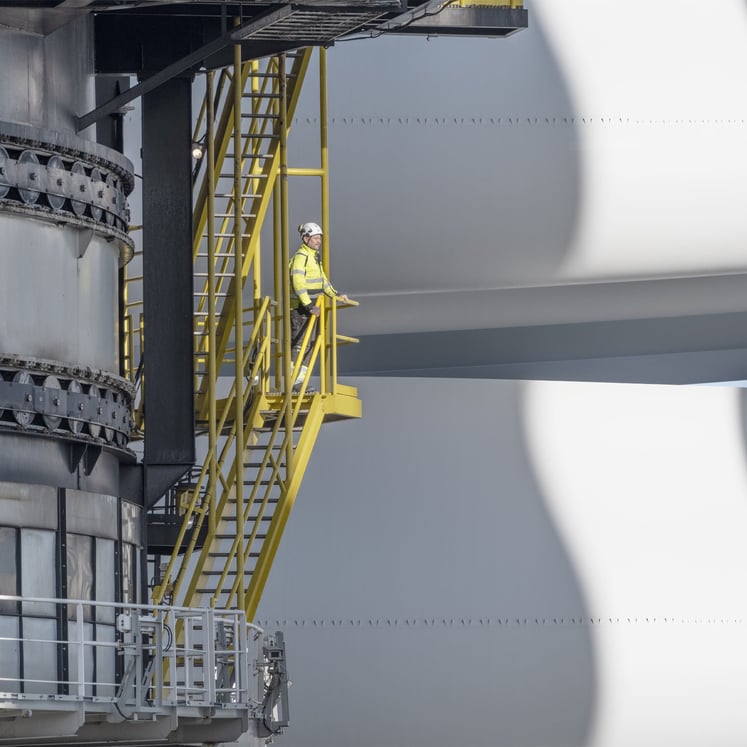 Ein Arbeiter blickt auf Komponenten einer Windkraftanlage in Hollandse Kust Zuid