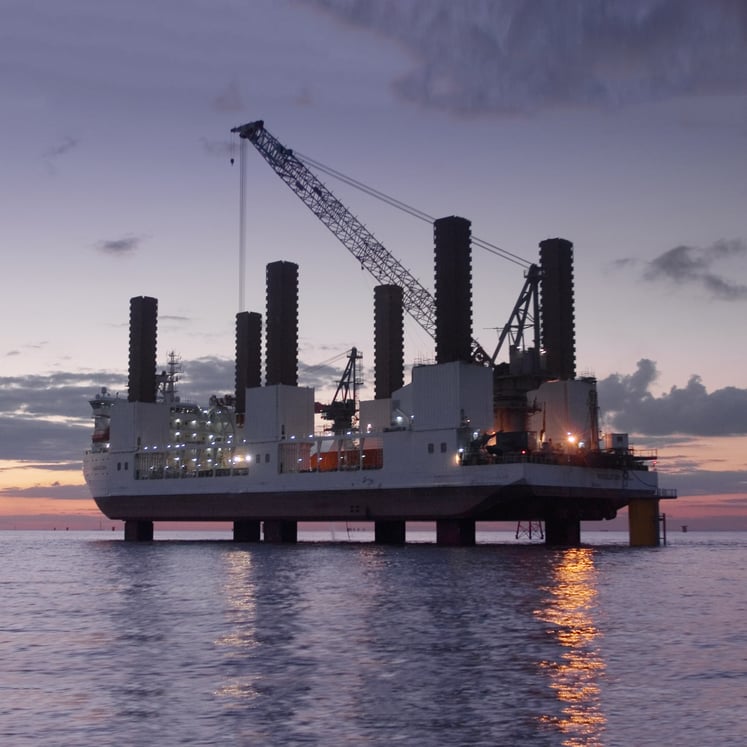 Eine Offshore-Plattform und ein Kran auf ruhiger See in der Abenddämmerung. Eine Offshore-Plattform und ein Kran auf ruhiger See in der Abenddämmerung.