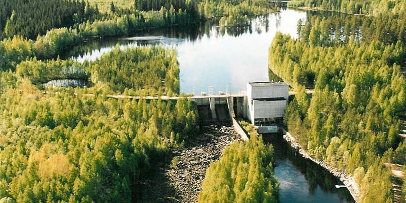 Wasserkraftwerk und Stausee zwischen bewaldeten Ufern. Wasserkraftwerk und Stausee zwischen bewaldeten Ufern.