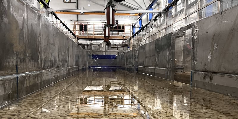 Der Laxelerator, ein großmaßstäbliches Labor mit einer langen Betonrinne und flachem Wasser in Innenräumen, in Älvkarleby. Foto: David Aldvén. Der Laxelerator, ein großmaßstäbliches Labor mit einer langen Betonrinne und flachem Wasser in Innenräumen, in Älvkarleby. Foto: David Aldvén.