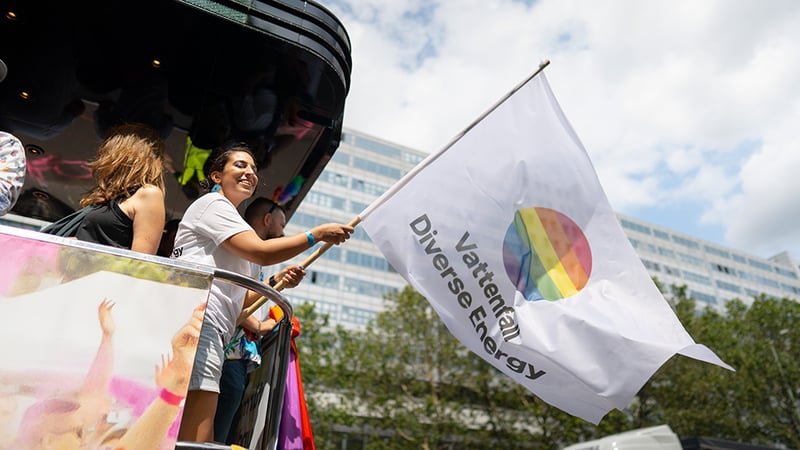 Vattenfall-Mitarbeiter schwenkt Vattenfall-Fahne beim CSD 2023