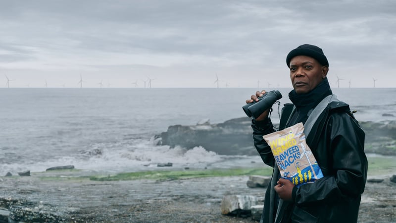 Schauspielikone Samuel L. Jackson mit Wind Farmed Seaweed Snacks in der Hand am Meer