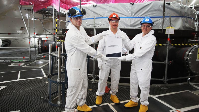 V. l.: Dr. Ingo Neuhaus, Schleswig-Holsteins Umweltminister Tobias Goldschmidt und Kraftwerksleiter Markus Willicks die symbolische zweite Abbaugenehmigung haltend vor dem Reaktordruckbehälter im Kernkraftwerk Brunsbüttel V. l.: Dr. Ingo Neuhaus, Schleswig-Holsteins Umweltminister Tobias Goldschmidt und Kraftwerksleiter Markus Willicks die symbolische zweite Abbaugenehmigung haltend vor dem Reaktordruckbehälter im Kernkraftwerk Brunsbüttel