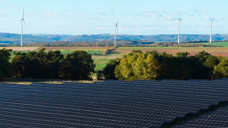 Onshore-Windkraftanlagen und Solarmodule in der hügeligen Eifellandschaft