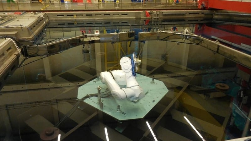 Blick in den mit Wasser gefüllten Reaktordruckbehälter, in dessen Mitte sich der Roboter im Ruhezustand befindet