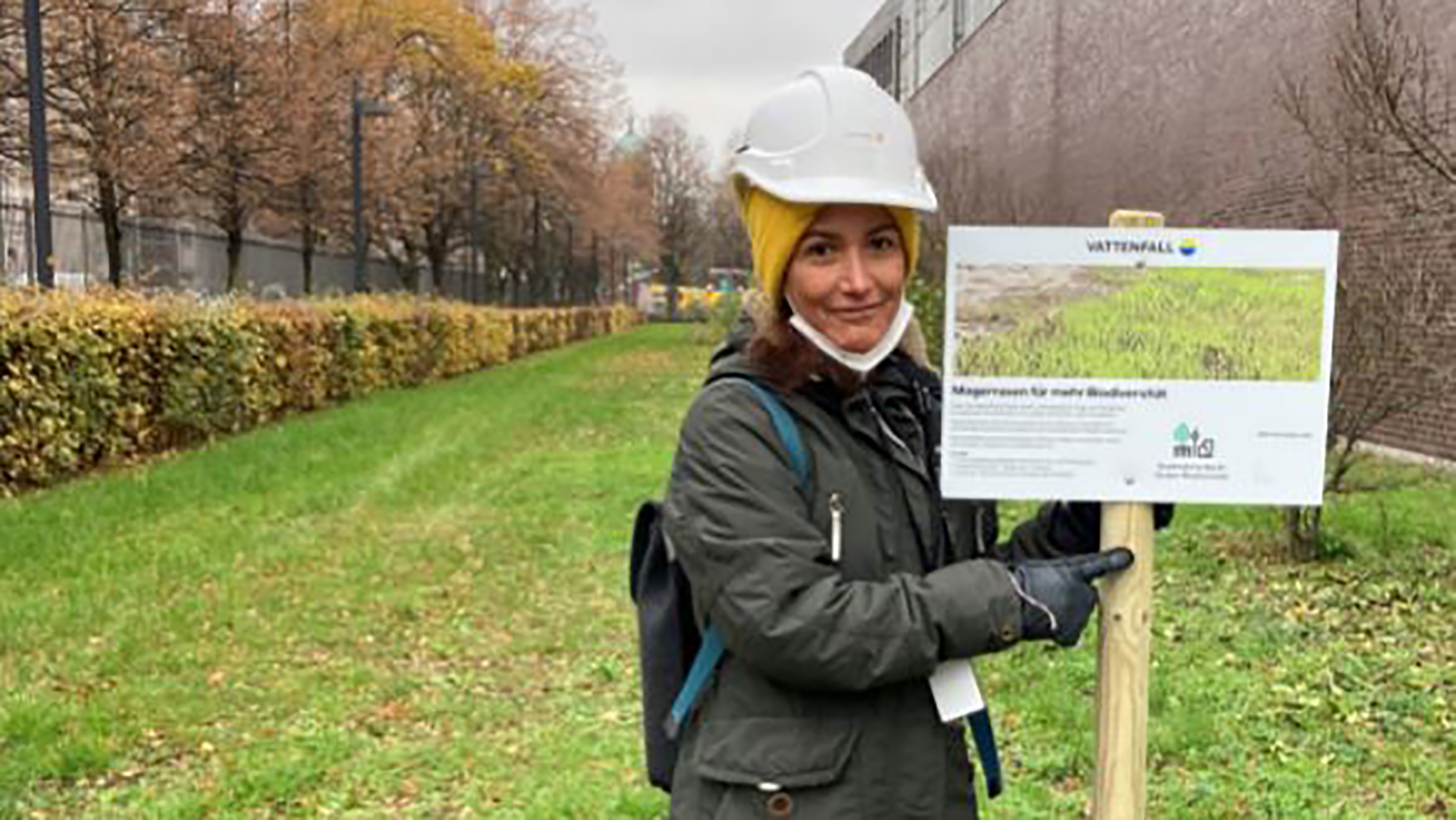 Gissela Riccio mit dem Hinweisschild "Magerrasen für mehr Biodiversität" am Vattenfall Wärme Standort Heizkraftwerk Mitte in Berlin 
