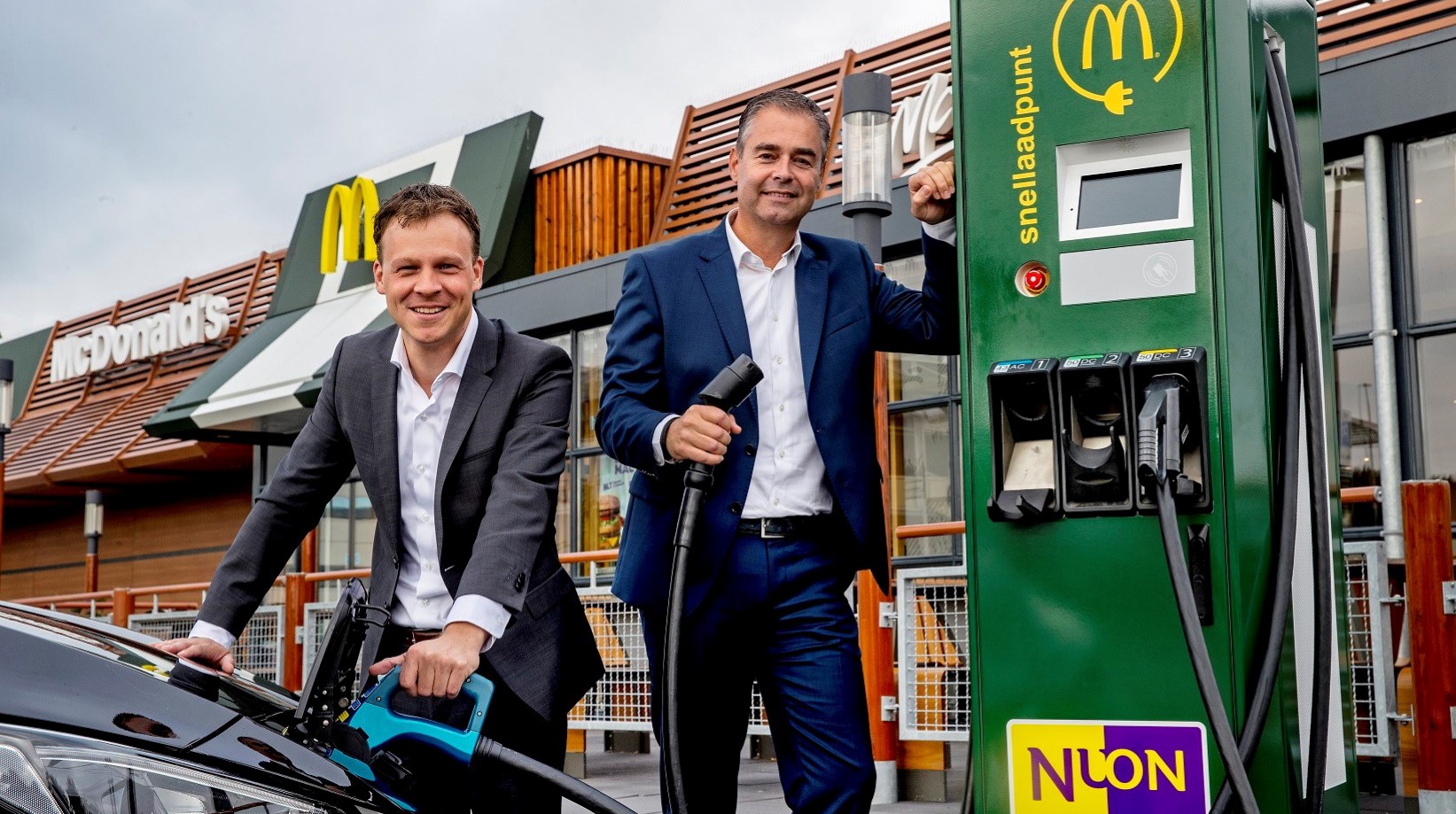 Pieter van Ommeren (links) und Bas Klaassen, Director Development Real Estate & Construction bei McDonald's, an der ersten Schnellladestation, die Nuon auf dem Gelände von McDonald's in Betrieb nehmen wird. 