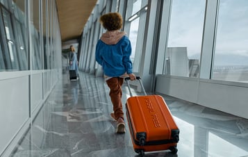 Et barn, der trækker en kuffert i en lufthavn