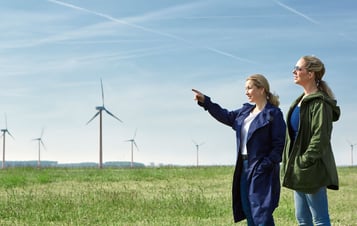 To kvinder foran en vindmøllepark