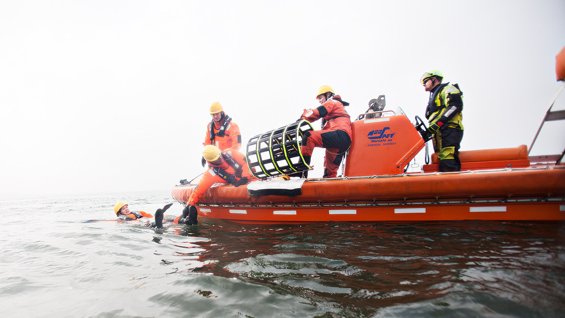 Deltagerne redder en kollega op af vandet på åbent hav med en ”redningsmåtte”.