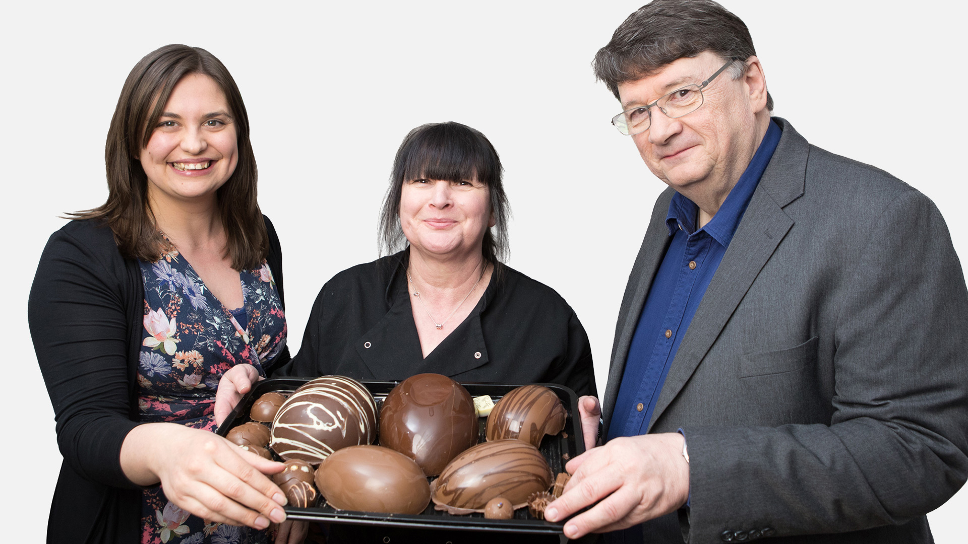 Emily Faull fra Vattenfall, Anita Angove fra Afan Vale Chocolates og Marc Phillips fra Pen y Cymoedd Wind Farm Community Fund CIC med en bakke chokolade