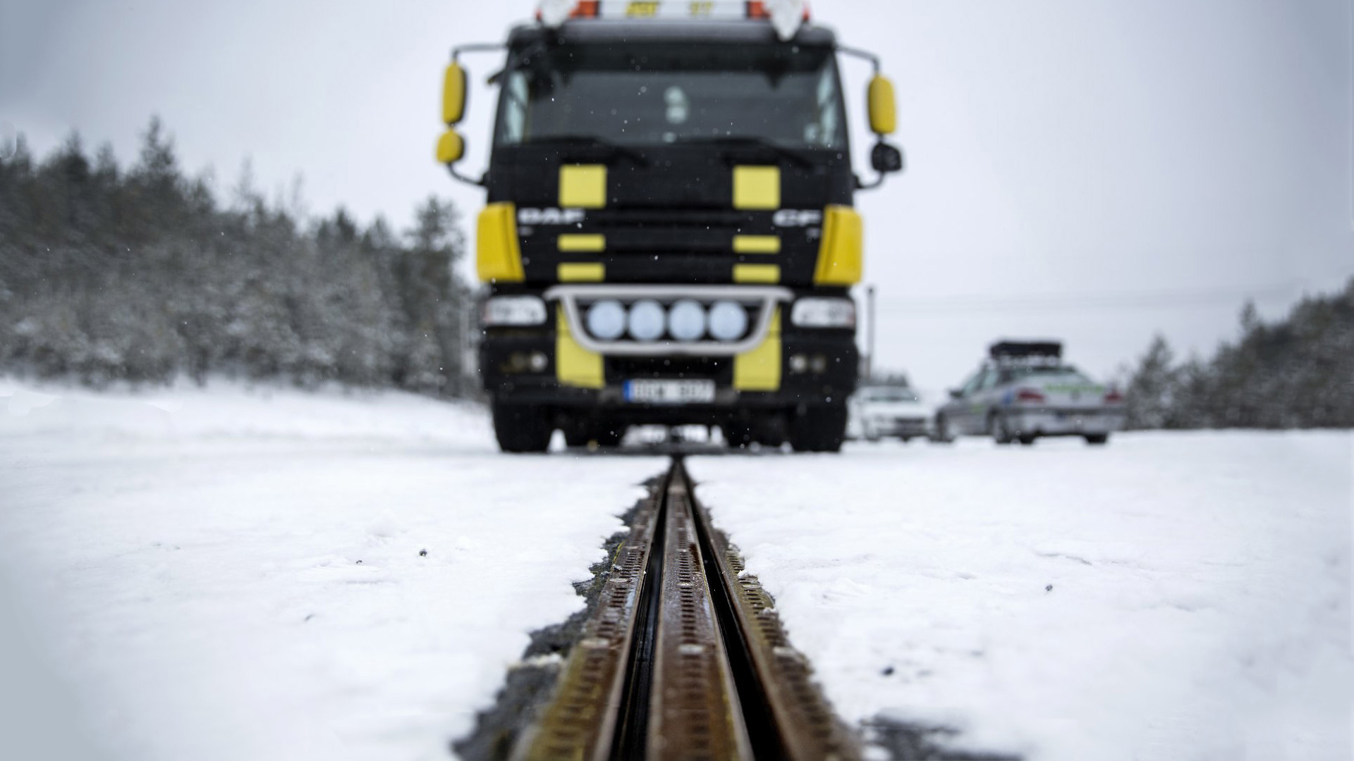 En lastbil kører på en elskinne i vejbanen