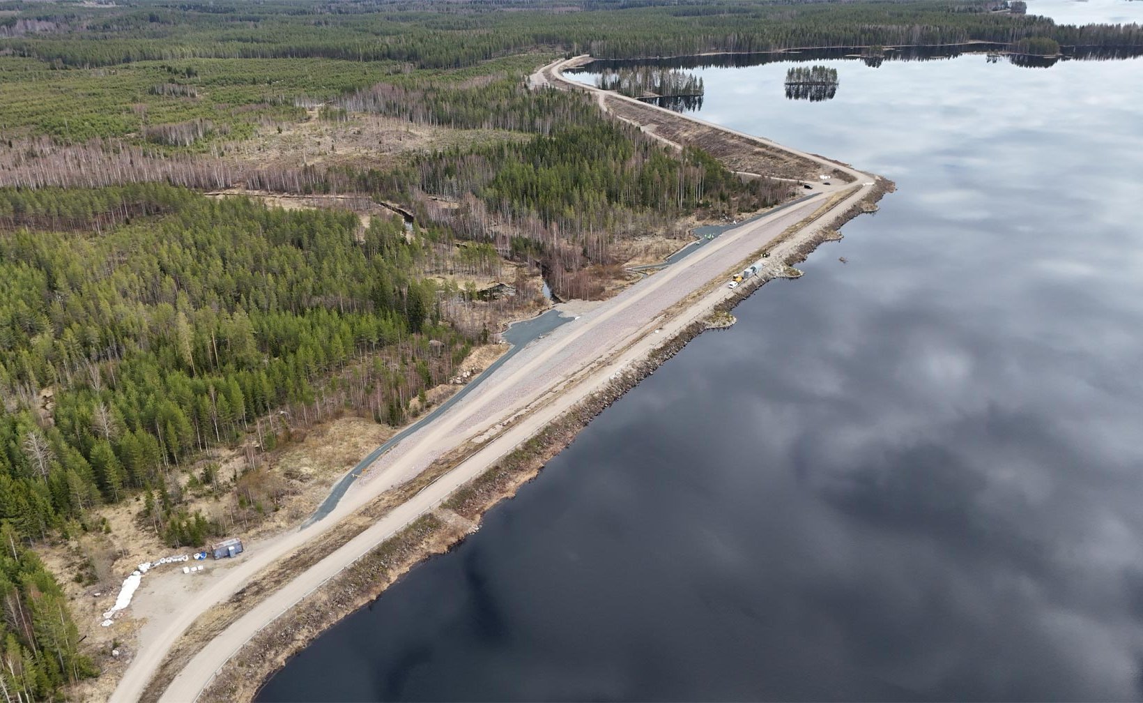 Ilmakuva padosta veden äärellä metsäisessä maisemassa. Ilmakuva padosta veden äärellä metsäisessä maisemassa.