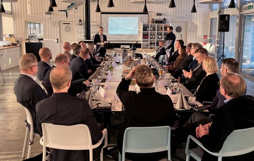 Offshore-tapahtuman osallistujat istuvat pöydän ääressä. Offshore-tapahtuman osallistujat istuvat pöydän ääressä.