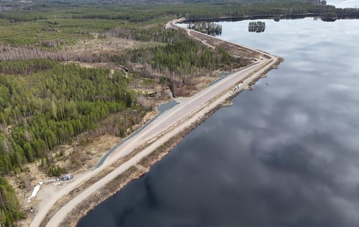 Ilmakuva padosta veden äärellä metsäisessä maisemassa. Ilmakuva padosta veden äärellä metsäisessä maisemassa.