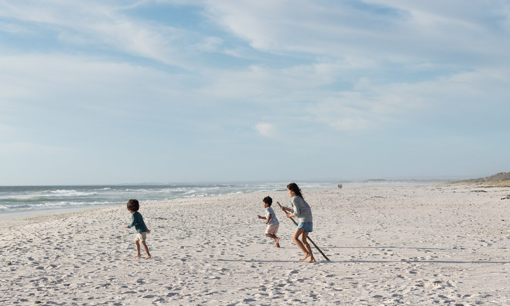 Trois enfants jouant sur une plage de sable Trois enfants jouant sur une plage de sable