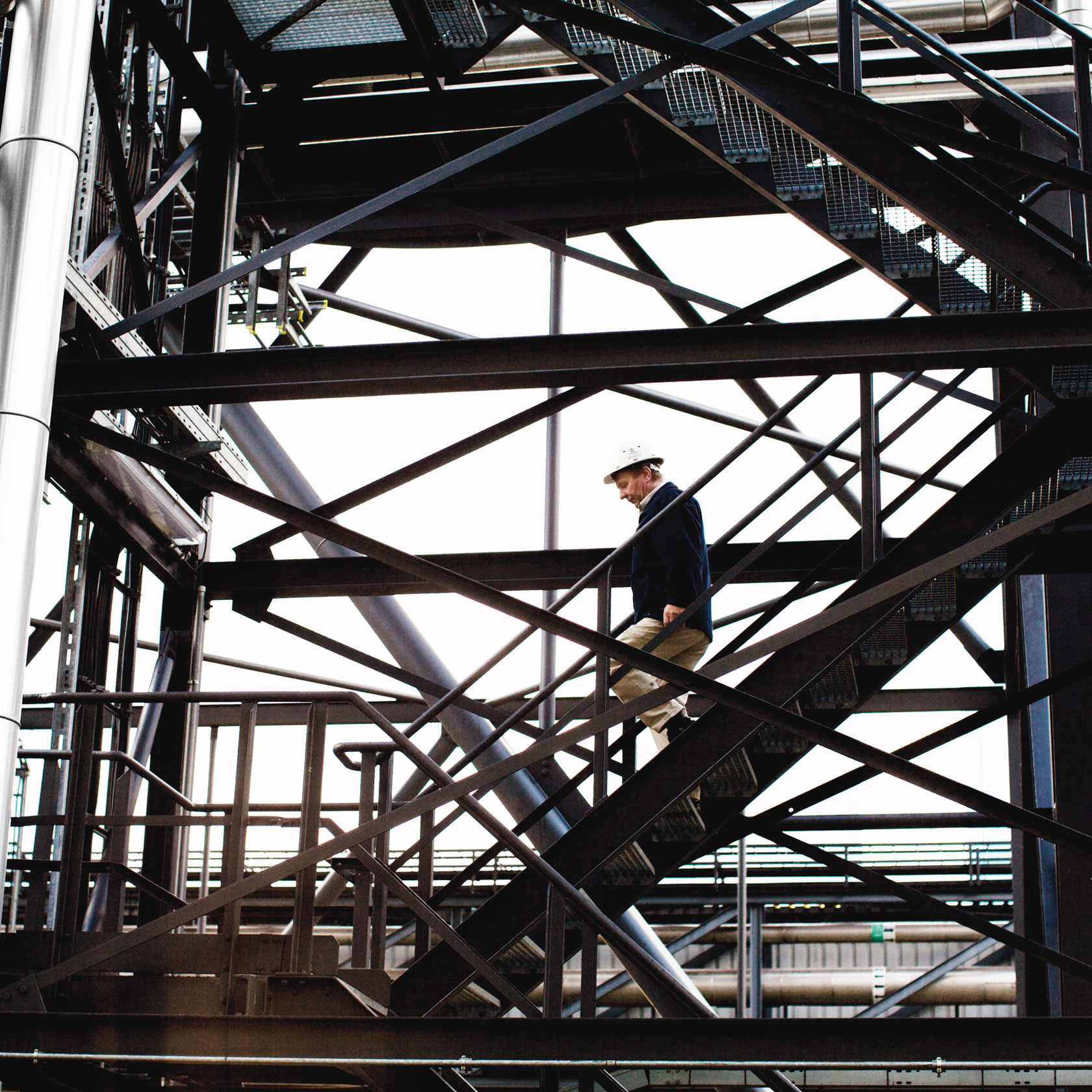 Employee walking up a staircase in a power plant