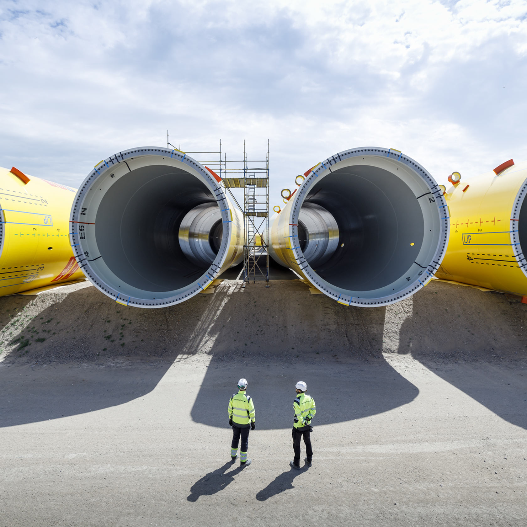 Two people in front of wind turbine components for the wind park Hollandse Kust Zuid