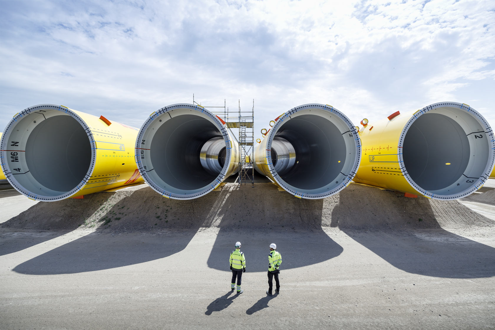 Two people in front of wind turbine components for the wind park Hollandse Kust Zuid