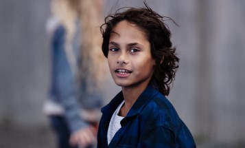 Boy with black hair looking into camera