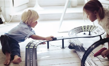 Two children playing with toy cars