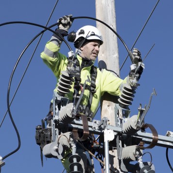 An employee at work at the top of an electricity pylon