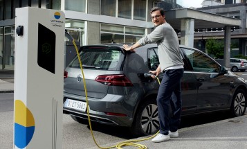 Mann lädt Elektroauto