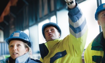 Mitarbeiter in Schutzkleidung nach oben schauend