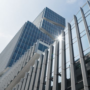 Sol som speglas i fasaden på kontorsbyggnad