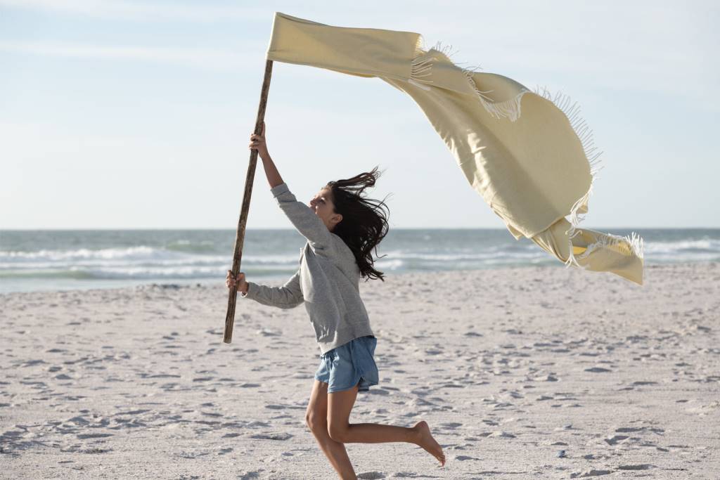 Mädchen am Strand mit Flagge in der Hand