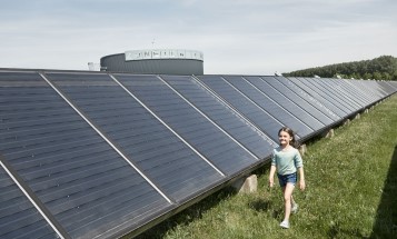 A girl walking at a solar farm.