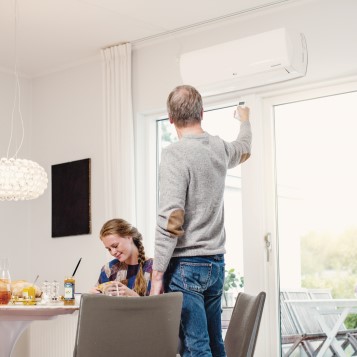 A woman and a man in a room with a heat pump