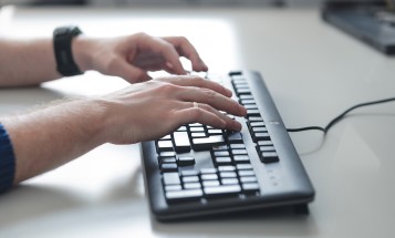 Hände auf einer Computertastatur