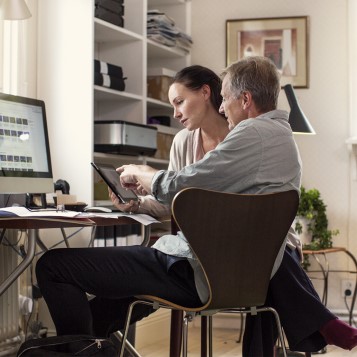 En mand og en kvinde, der sidder ved et computerskrivebord