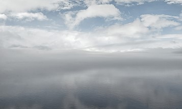 Lätta moln som speglas i en sjö