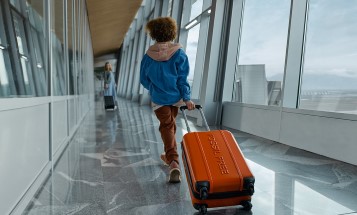 Et barn, der trækker en kuffert i en lufthavn
