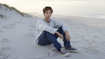 A boy sitting on a shore