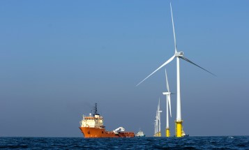 Ett fartyg intill en havsbaserad vindkraftspark