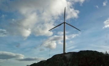 Ett vindkraftverk i motljus