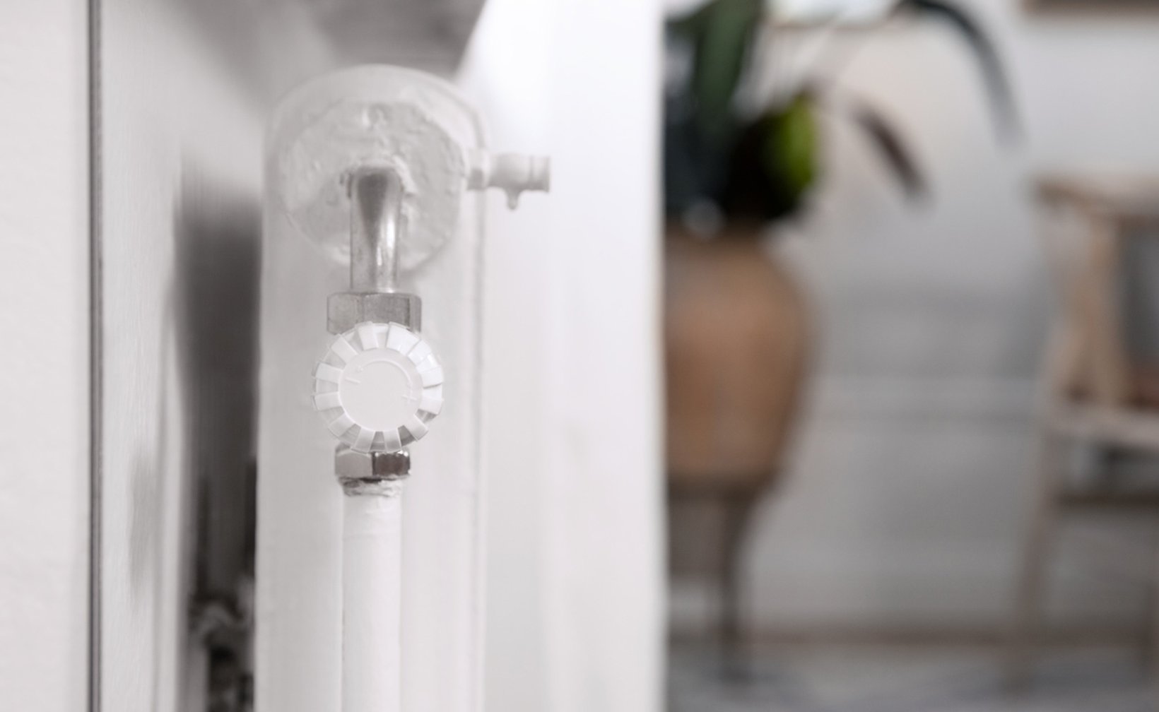 Witte radiator met thermostatische radiatorkraan in een woning.