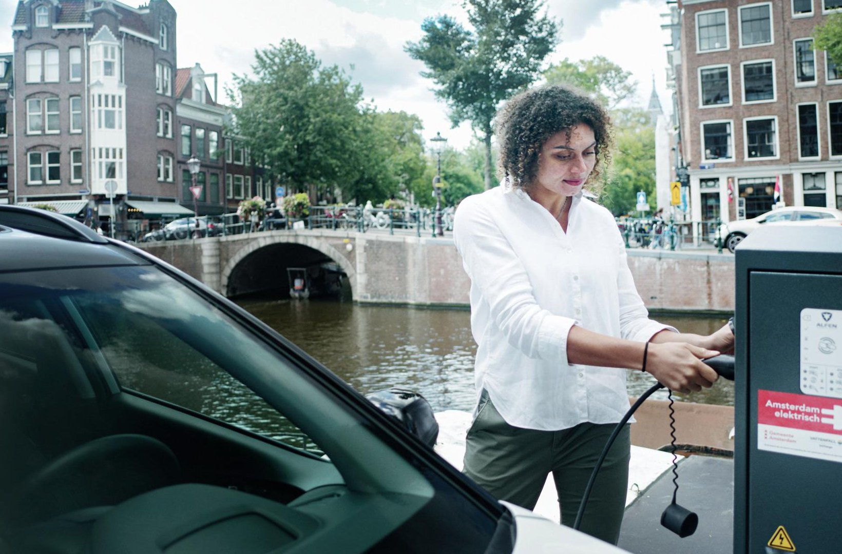 Vrouw laadt auto op aan een Amsterdamse gracht_Vattenfall