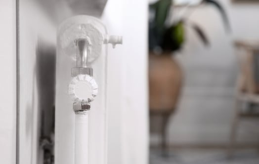 Witte radiator met thermostatische radiatorkraan in een woning. Witte radiator met thermostatische radiatorkraan in een woning.