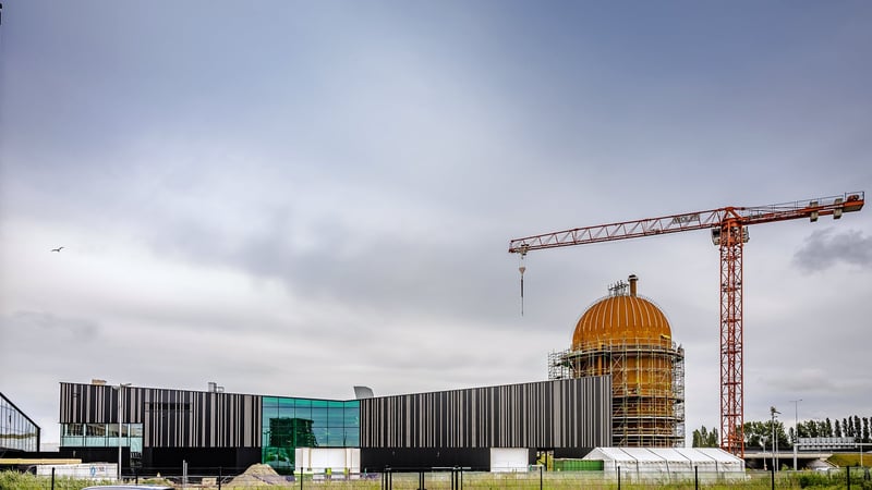 Links het warmteoverdrachtstation (WOS) waar de havenwarmte binnen zal komen, rechts (roestkleurig) de warmtebuffer waar de warmte kan worden opgeslagen.