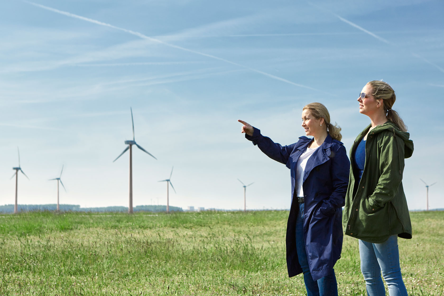 Twee vrouwen die zich dicht bij een windmolenpark bevinden