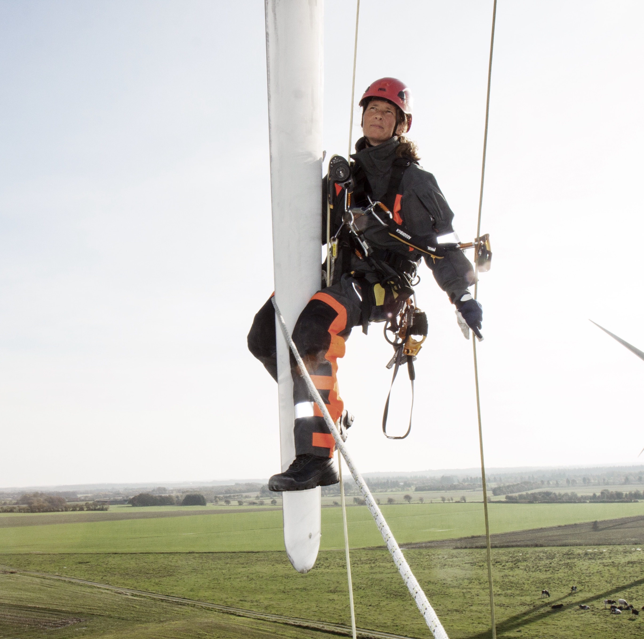 Woman hanging on a wind turbine