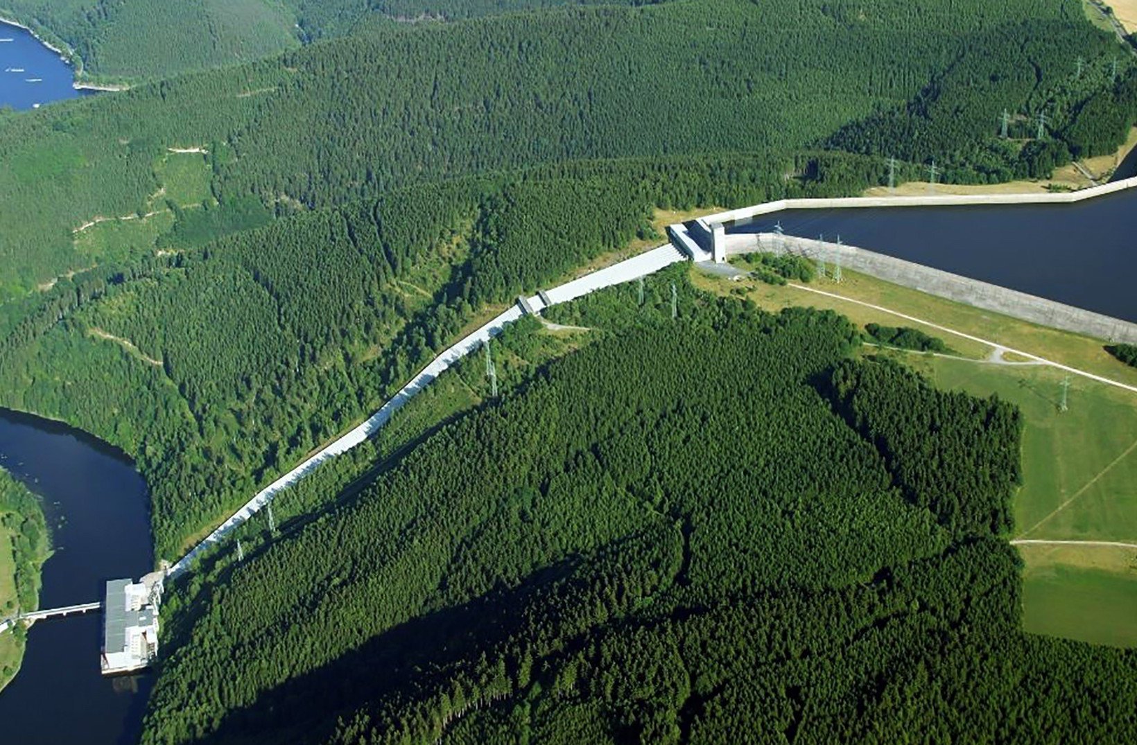 Flygfoto över pumpkraftverket Hohenwarte II och dess reservoar, omgivna av tät skog.