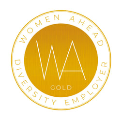 En rund guldfärgad och vit symbol med texten Women Ahead, diversity employer gold.