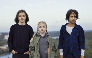Tre barn står på en kulle. Tre barn står på en kulle.