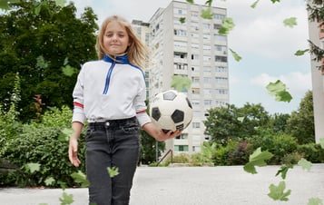 En flicka som håller en fotboll